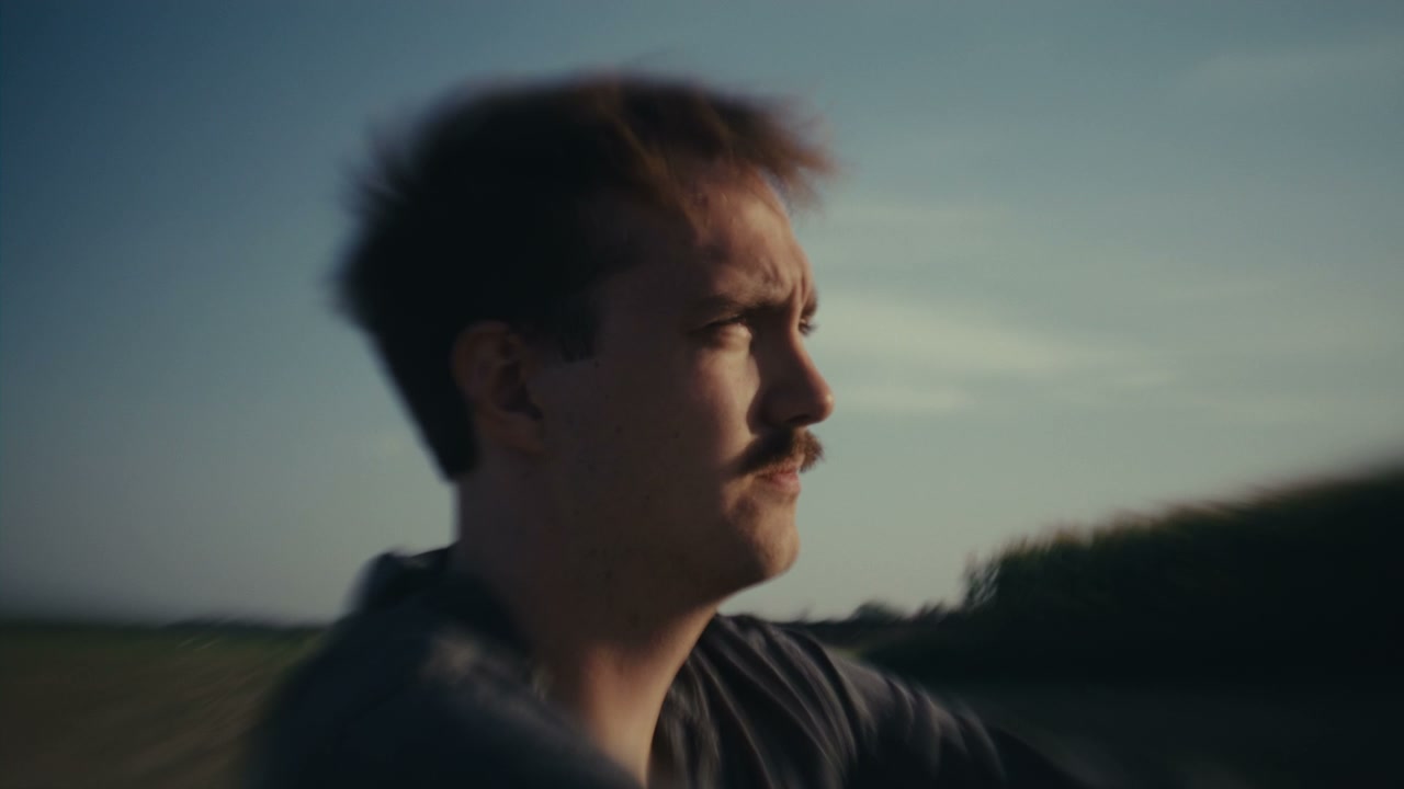 Pensive Man in Moving Vehicle at Sunset
