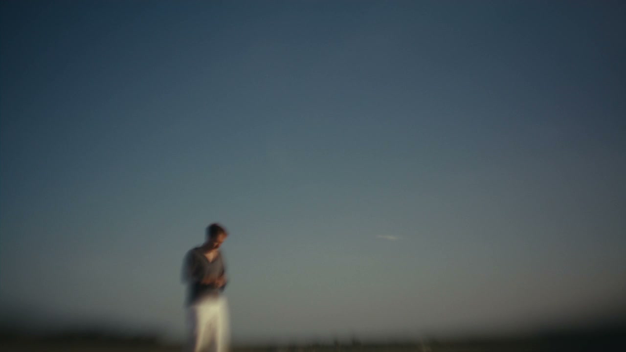 Pensive Man Looks Up at Blue Sky