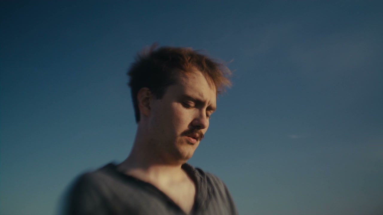 Distressed Man Rubs Face Under Blue Sky