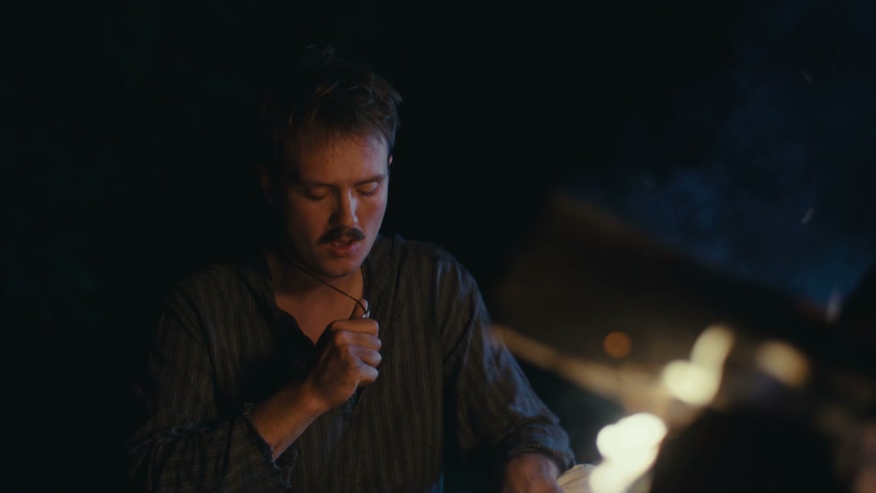 Pensive Man Sitting by Campfire