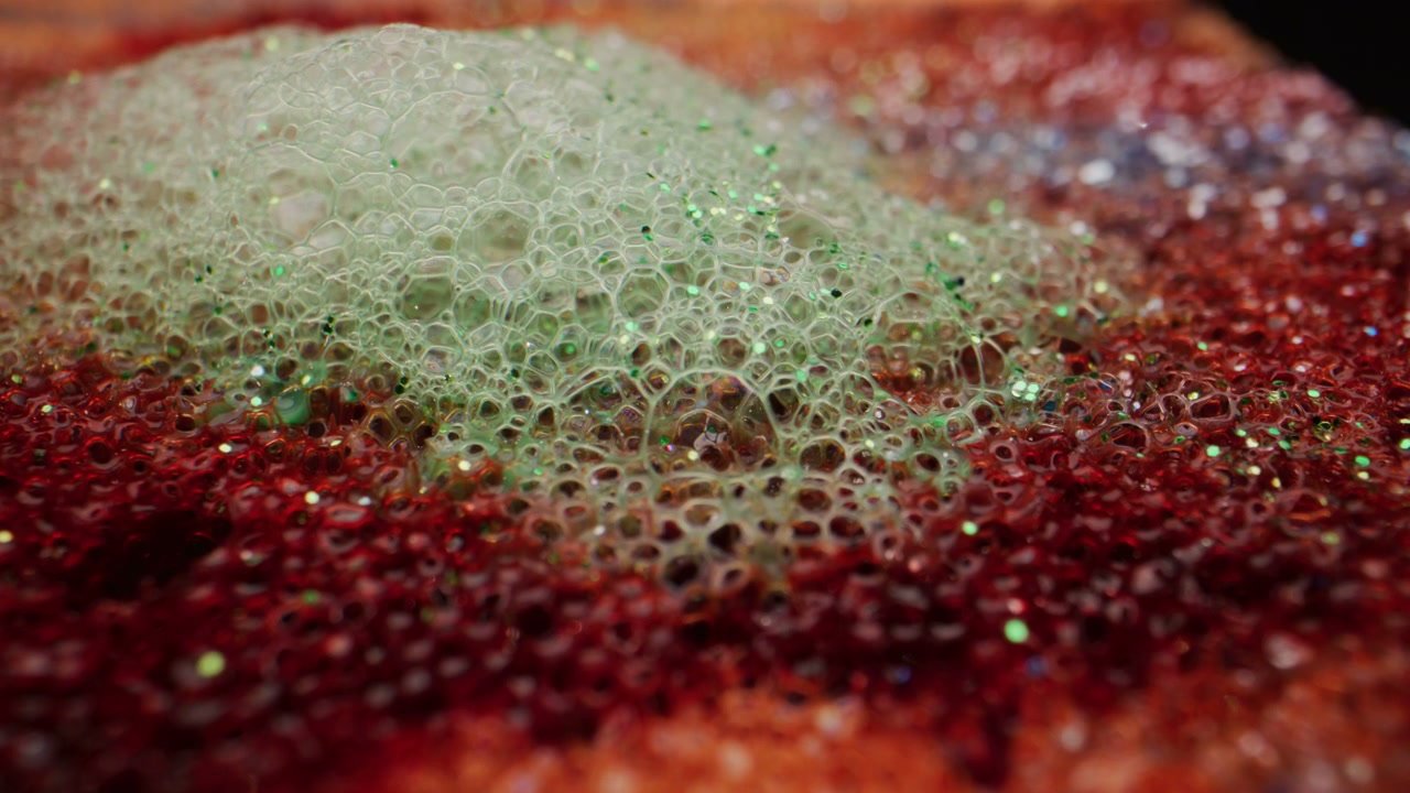 Green Foam on Red Glitter Surface