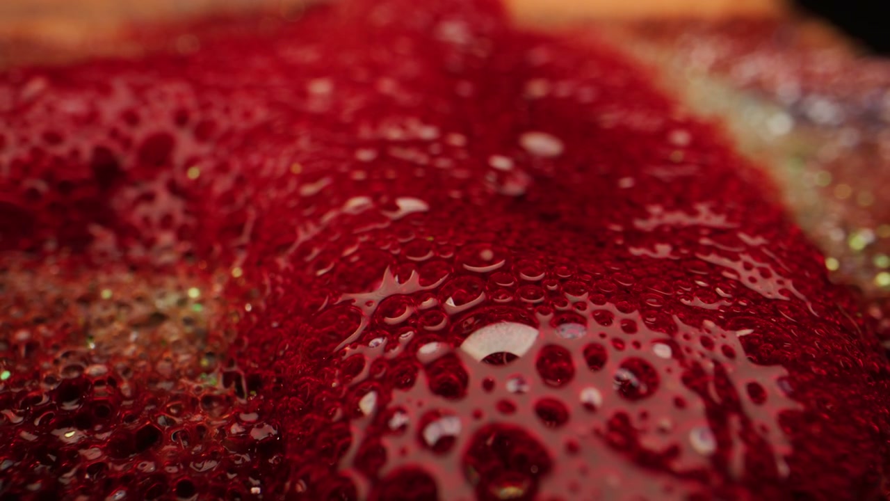 Shimmering Red Liquid Surface with Bubbles