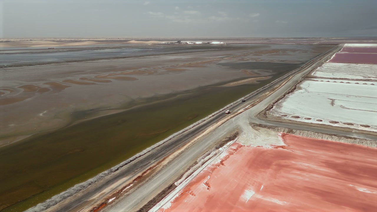 Aerial View of Vehicle Driving Through Salt Ponds