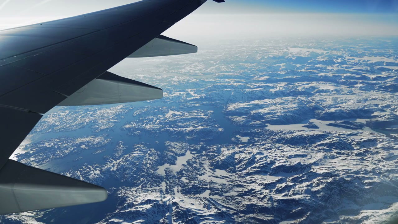 Airplane Wing View Over Snow-Covered Greenland