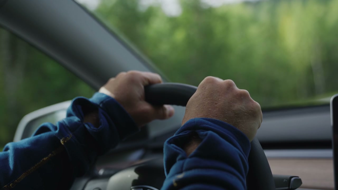 Person's Hands Driving an Electric Car