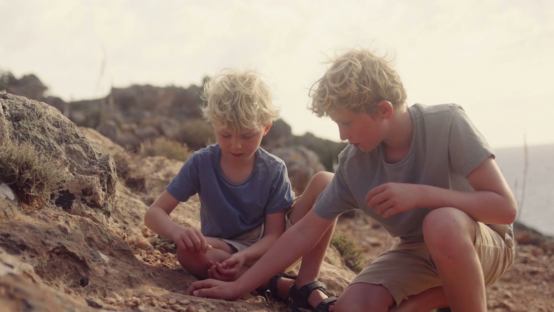 Boys Playing with Rocks on Rocky Coast • Stock Video on Uppbeat