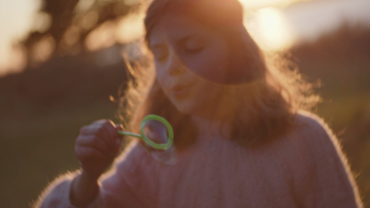 Girl Blowing Bubbles at Sunset