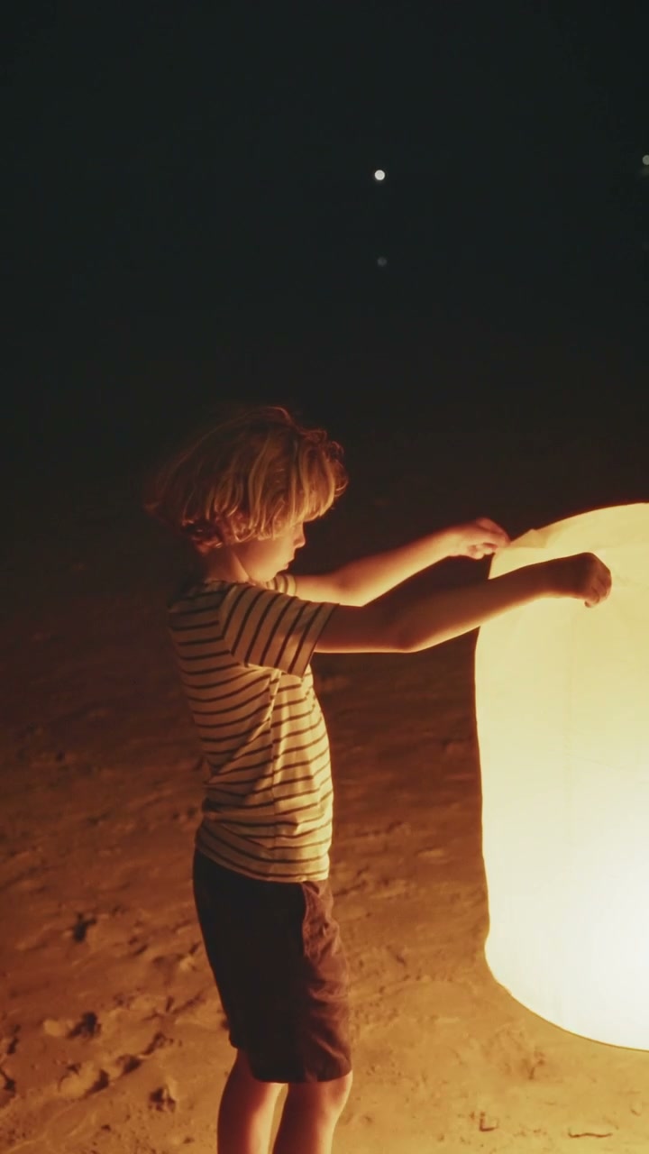 Child Holding Glowing Lantern at Night