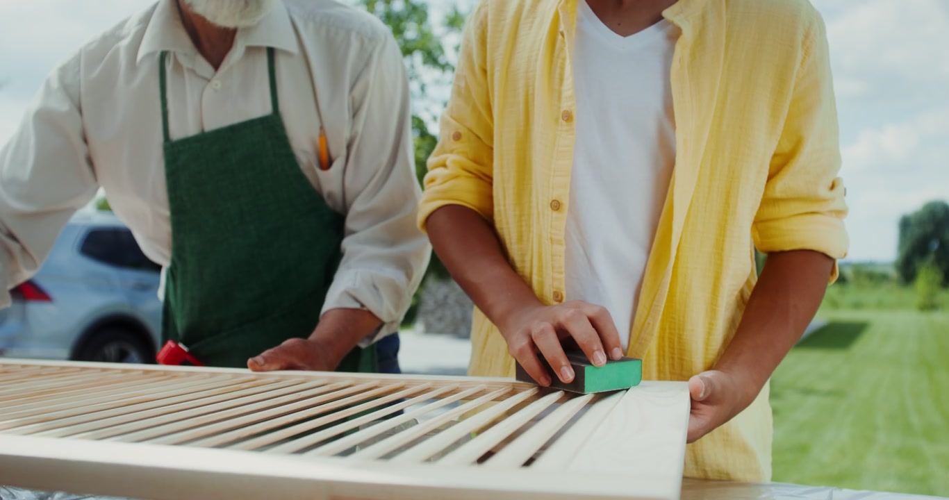 Grandfather and Grandson Sanding Wood Panel