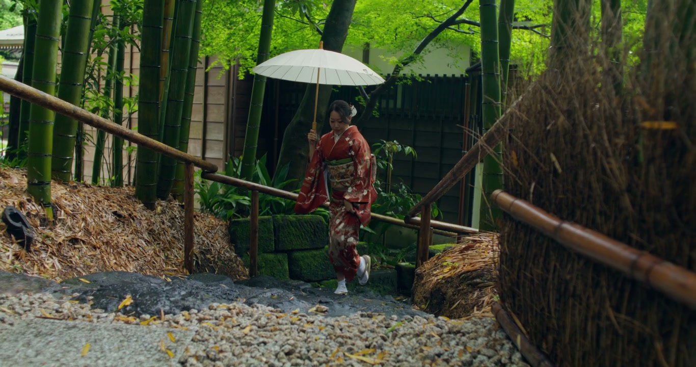 Japanese Woman in Kimono with Umbrella in Bamboo Garden