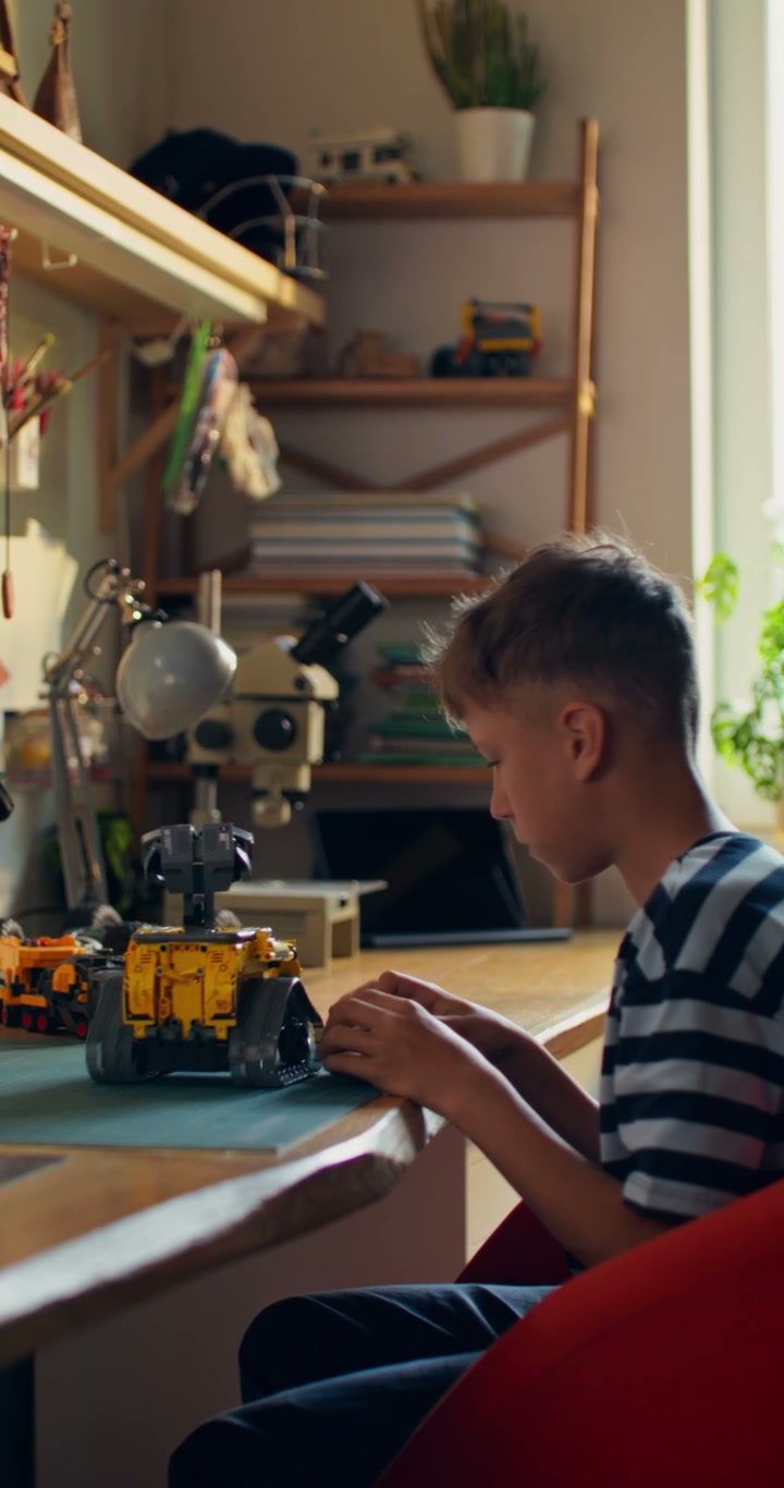 Boy Assembling Toy Robot at Desk