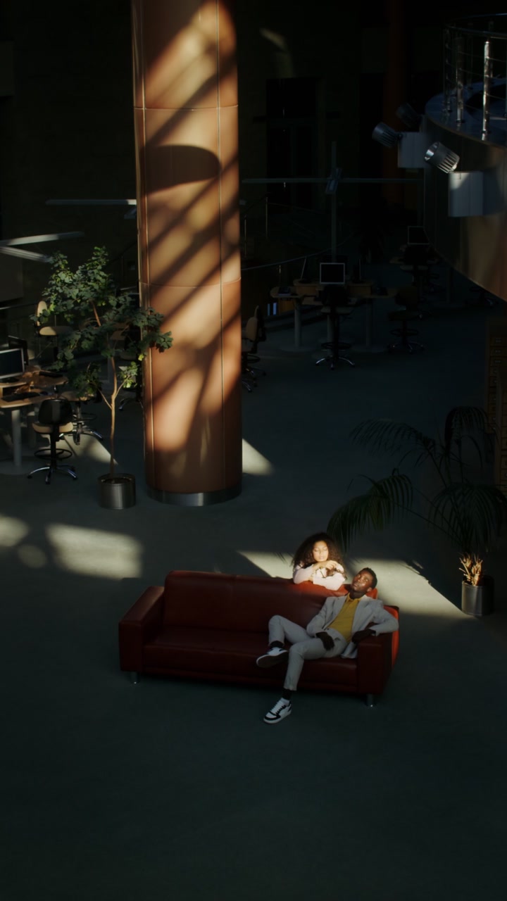 Business People Relaxing in Sunny Office Lobby