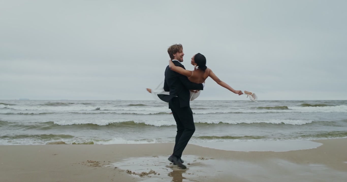 Groom Lifts and Spins Bride on Beach