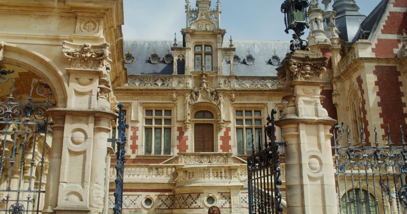 Person Walking Towards Ornate Historic Chateau