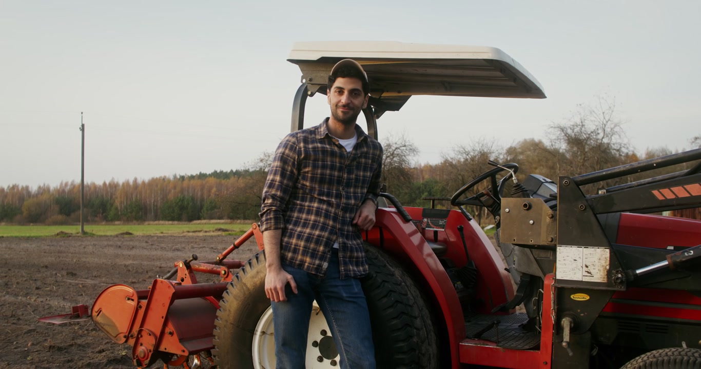Farmer Adjusting Cap by Tractor