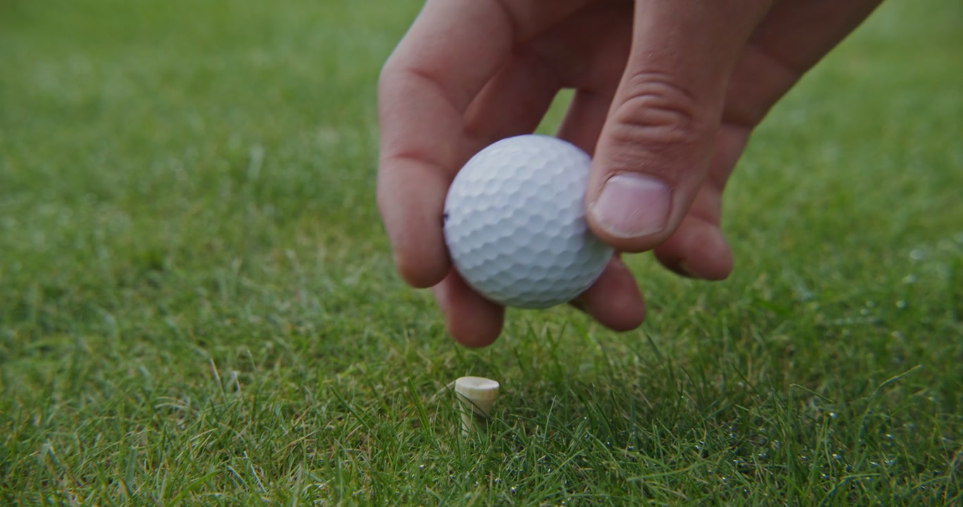 Hand Placing Golf Ball on Tee