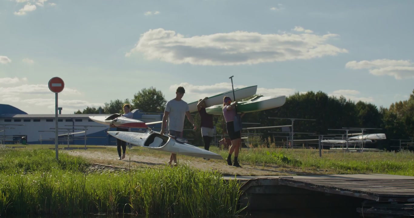 Athletes Carrying Kayaks to Dock