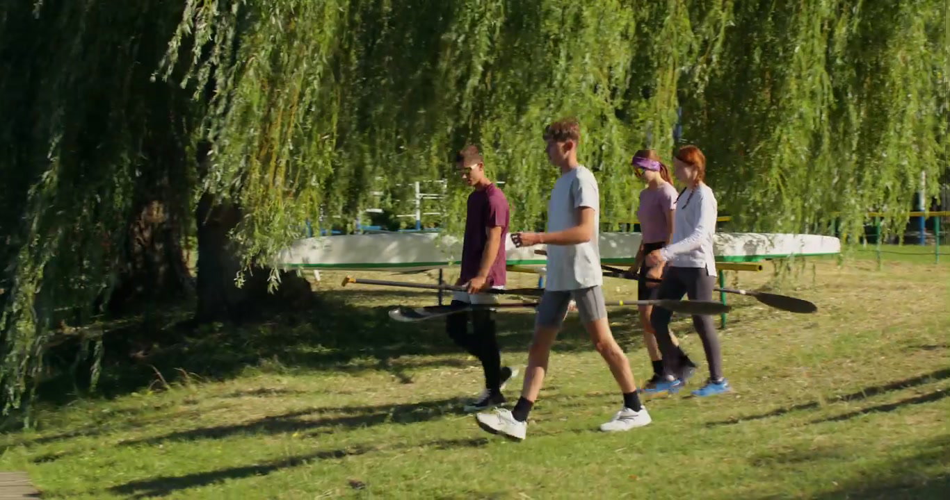 Young People Carrying Paddles to Lake