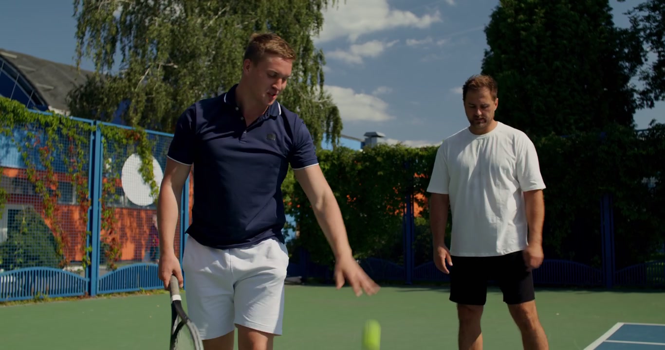 Men Practicing Tennis Serves on Court